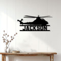 Black helicopter silhouette metal sign displayed on a light wood-paneled wall in a modern home