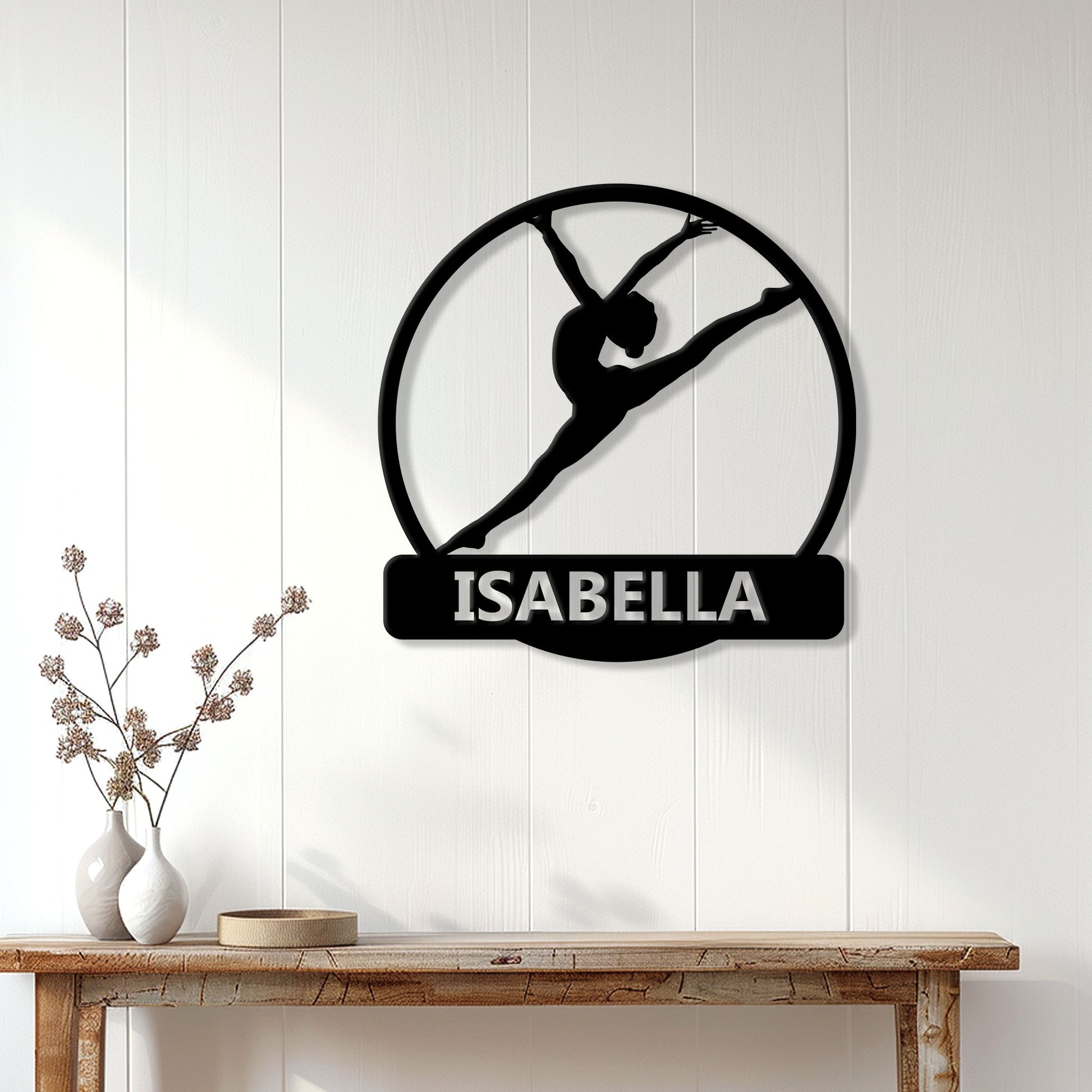 Black gymnastics silhouette metal sign displayed on a bright paneled wall above a console table