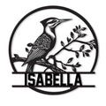 Detailed woodpecker metal sign featuring a bird perched on a leafy branch within a circular frame