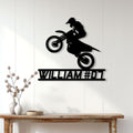 Black motocross rider metal wall sign displayed on white paneled home decor wall