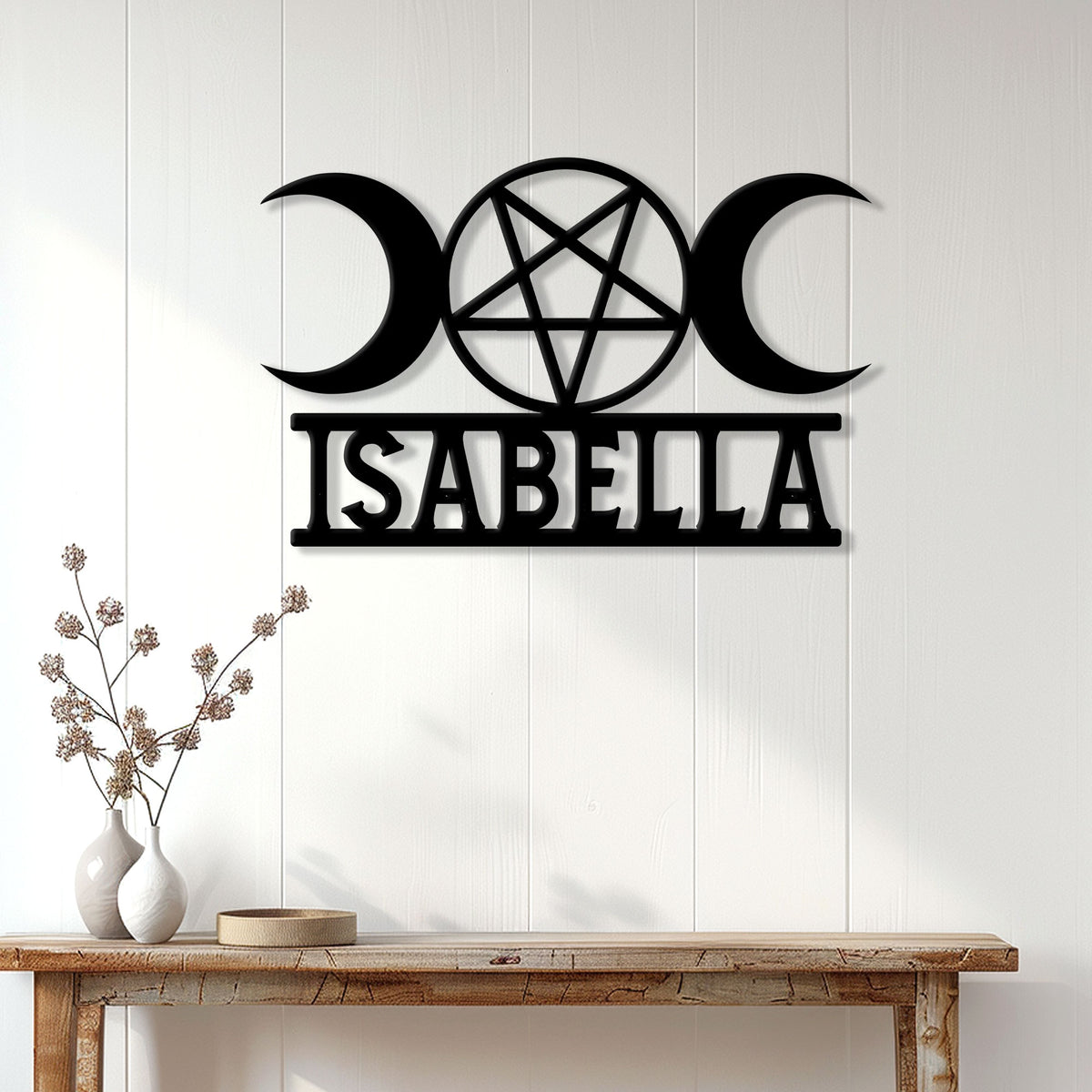 Triple moon and pentagram Wicca wall sign displayed on a light wood-paneled wall above a console table
