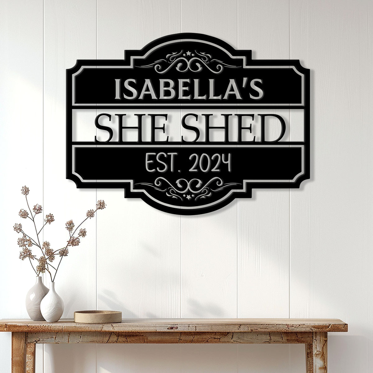 Elegant She Shed metal sign displayed on a white paneled wall above a wood console table