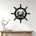 Black crab and nautical wheel wall sign displayed on a white paneled wall