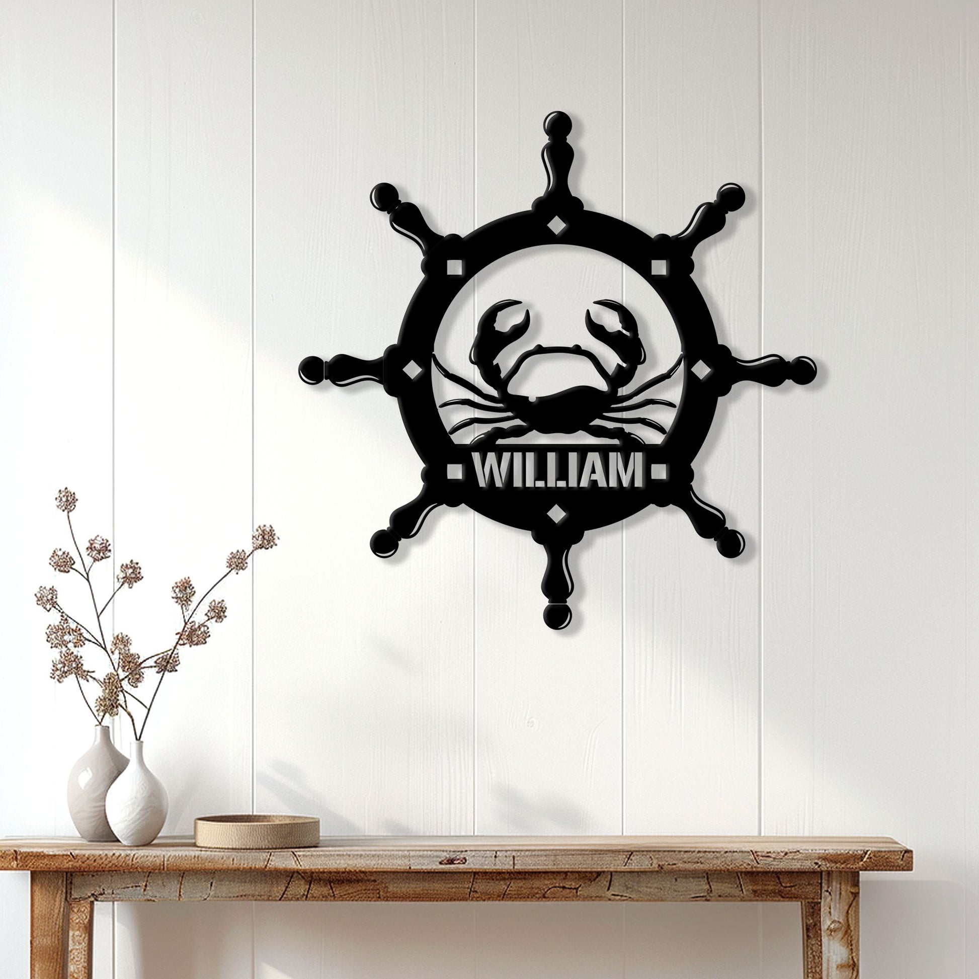 Black crab and nautical wheel wall sign displayed on a white paneled wall