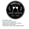 Round cut-metal She Shed sign featuring wine glasses and a bold black design