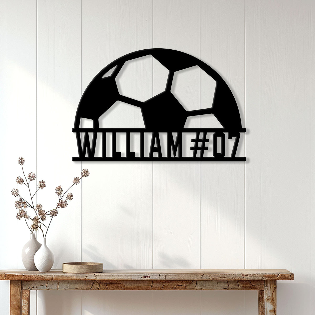 Soccer ball metal wall sign styled above a console table in a bright home interior