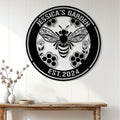 Bee garden metal sign displayed on a white paneled wall above a console table in a bright home