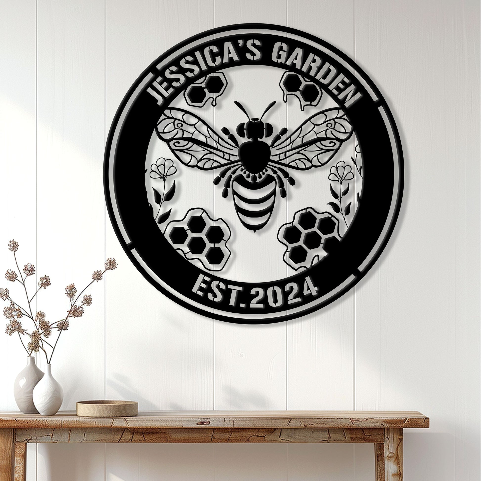 Bee garden metal sign displayed on a white paneled wall above a console table in a bright home