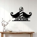 Black mustache and barber pole wall sign displayed on a light wood-paneled entryway