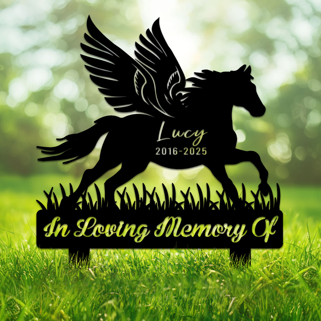 Winged horse silhouette memorial metal sign displayed in a green garden setting
