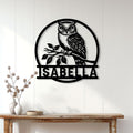 Black owl wall sign displayed on a white paneled wall above a rustic console table
