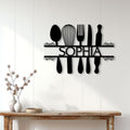 Black kitchen utensil metal sign mounted on a bright farmhouse-style wall