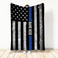Person holding a police throw blanket featuring distressed stars, stripes, and thin blue line artwork