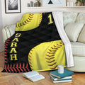 Softball throw blanket with yellow softball artwork, black geometric background, and red stitching accents