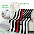 Firefighter blanket draped over a sofa with thin red line flag artwork and cozy texture details