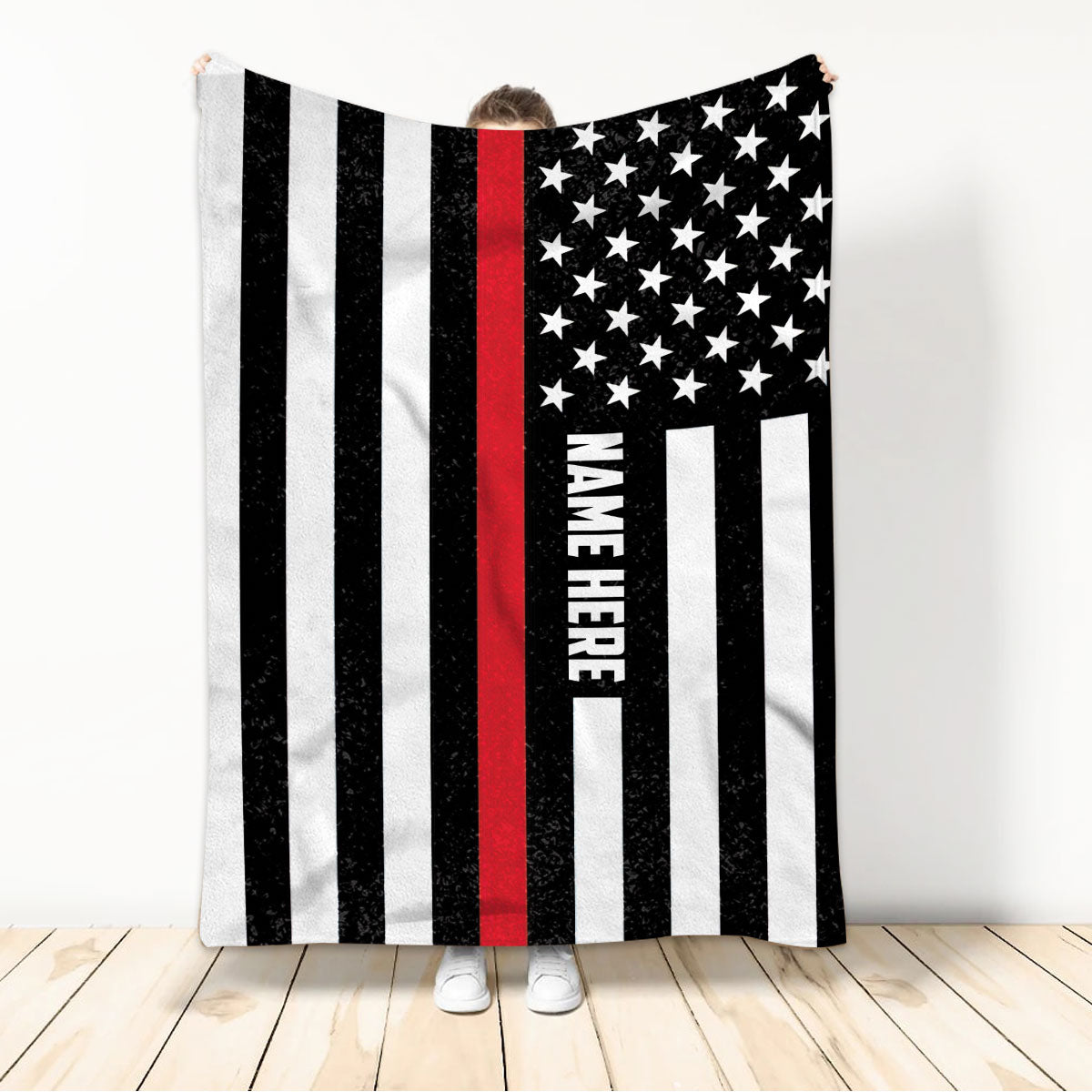 Firefighter throw blanket displayed by a person, featuring black, white, red, and star flag artwork