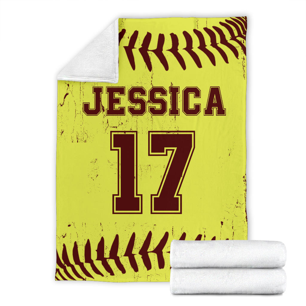 Softball blanket displayed flat with yellow and burgundy sports artwork and folded blanket detail