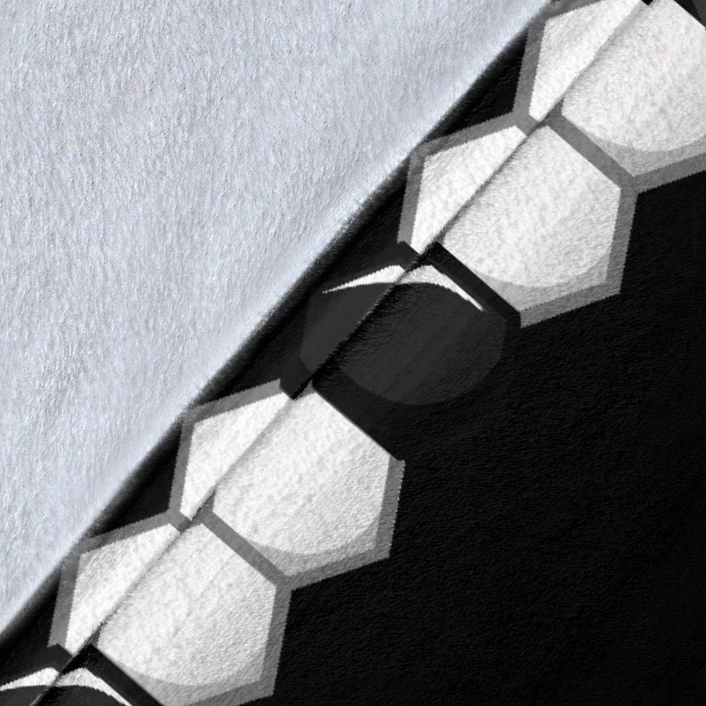 Close-up view of soft blanket texture with black and white soccer ball pattern