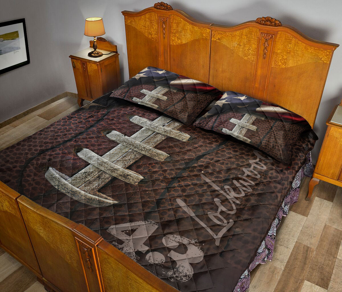 Football quilt blanket shown in a bedroom with large laced football artwork and dark sports-inspired colors