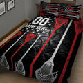 Close bedroom view of a black lacrosse quilt blanket with red and white sticks and star accents