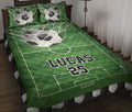 Green soccer quilt blanket displayed on a bed with soccer balls, field markings, and matching pillow artwork