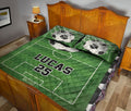 Soccer-themed quilt blanket styled across a bedroom with green field graphics and soccer ball artwork