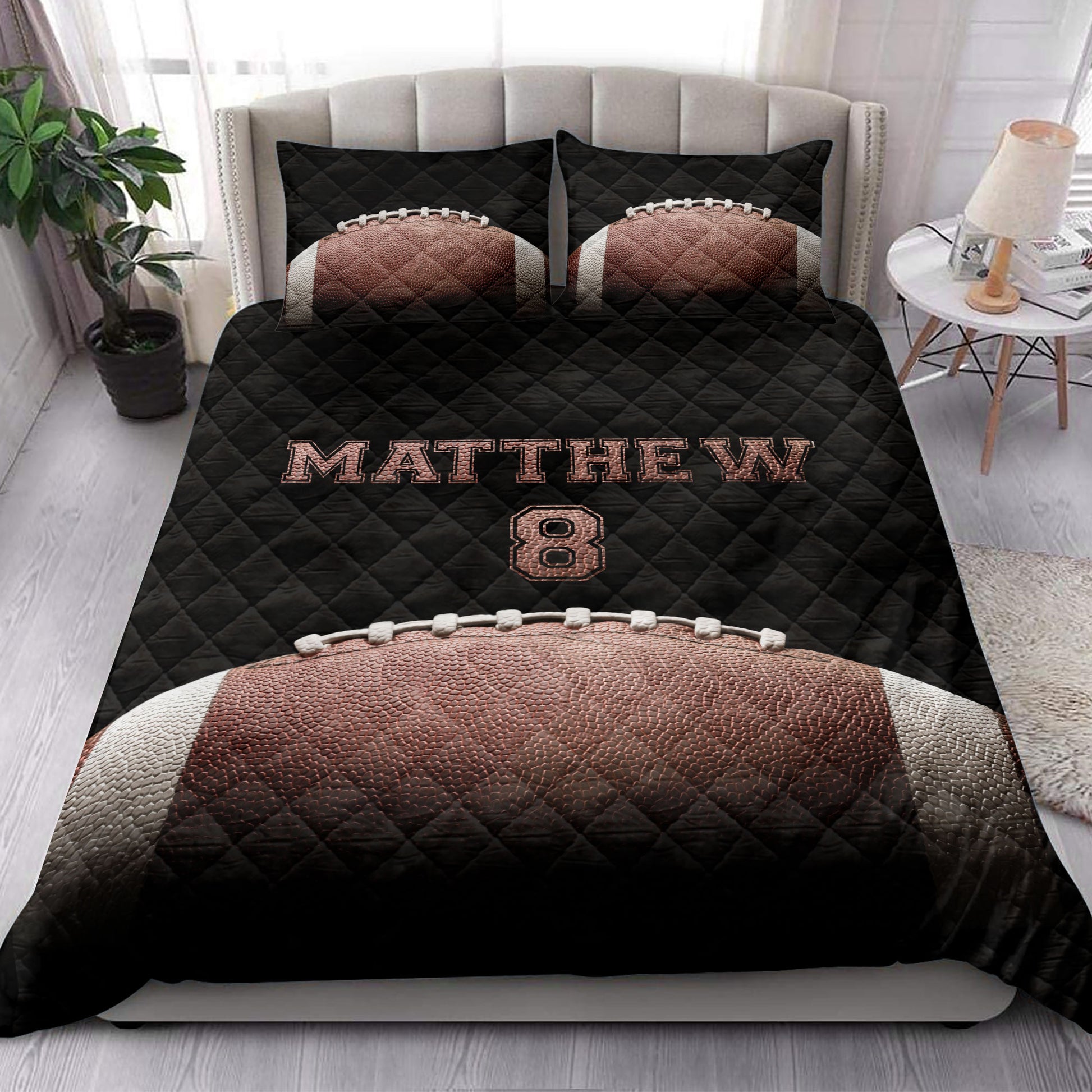 Football quilt bedding styled in a bright bedroom with bold black and brown sports artwork