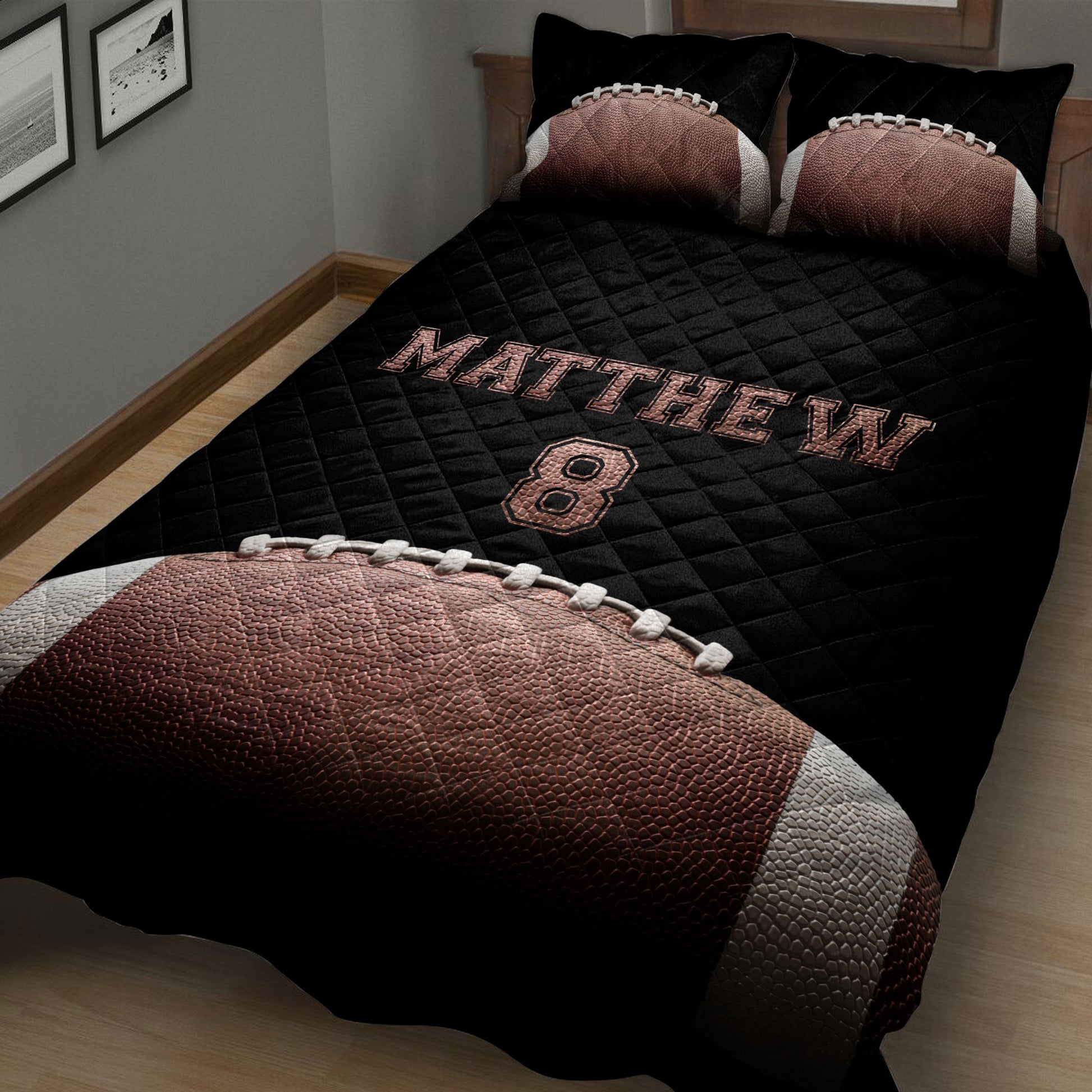 Close bedroom view of black football quilt blanket with football artwork and coordinating pillows