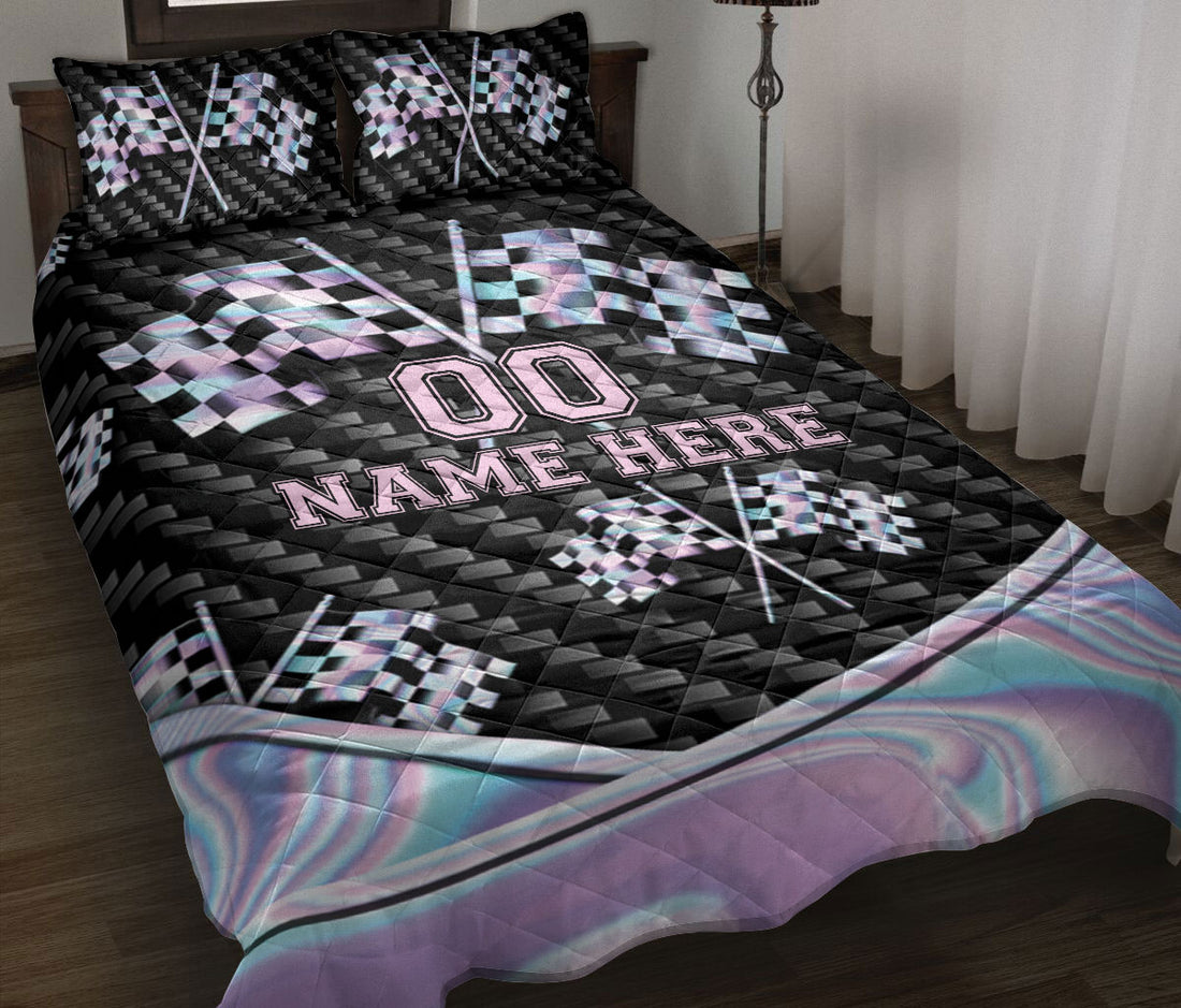 Racing quilt blanket displayed on a bed with checkered flags, black geometric artwork, and pastel accents
