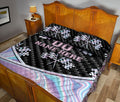 Racing quilt blanket styled across a bedroom with checkered flags and colorful motorsport artwork