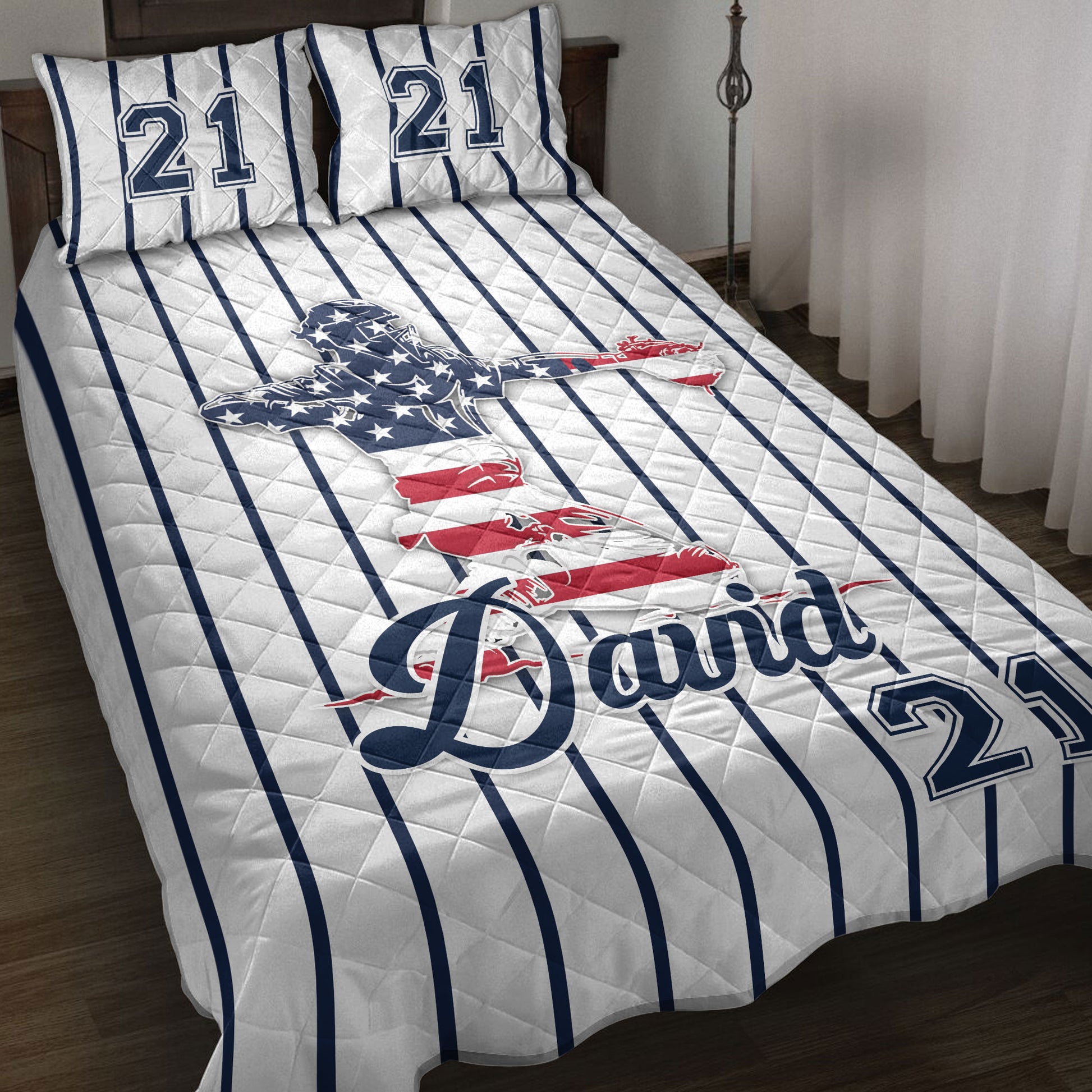 Baseball quilt blanket styled on a bed with patriotic ballplayer artwork and striped sports design
