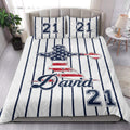 Baseball quilt blanket displayed in a bright bedroom with striped sports artwork and ballplayer design