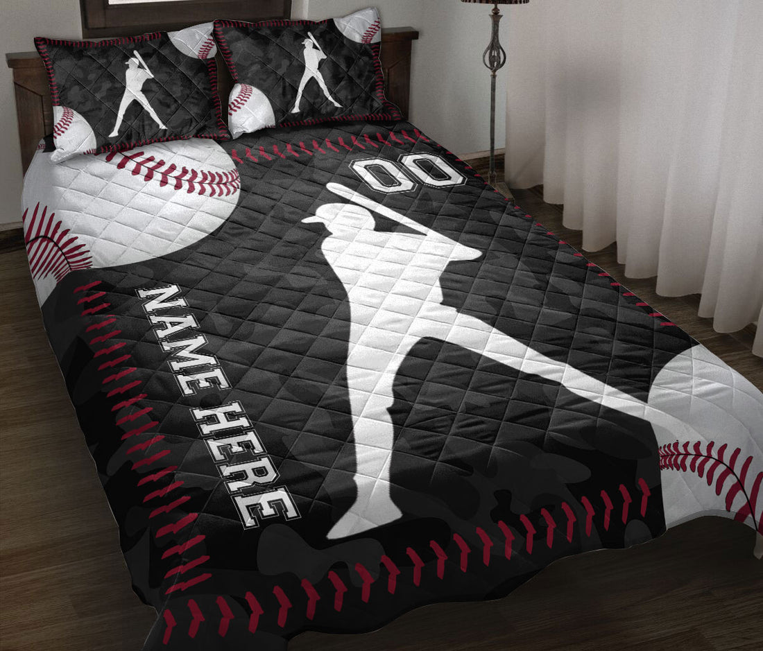 Baseball quilt blanket displayed on a bed with batter silhouettes, baseballs, and black and red sports artwork