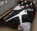Baseball quilt blanket on a bed featuring oversized baseballs, batter silhouettes, and red stitching details