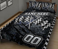 Black racing quilt blanket with crossed checkered flags and graphic motorsport design on a bed