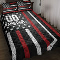 Hockey quilt blanket displayed on a bed with black, red, and white stripes, stars, and hockey stick artwork