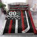 Hockey quilt blanket styled on a bedroom bed with bold red, white, and black hockey graphics