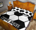 Black and white soccer ball bedding styled across a bedroom bed with matching pillows
