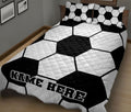 Soccer ball quilt blanket displayed on a bed in a modern black and white bedroom