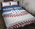 Baseball quilt blanket styled on a bed with red stitching, blue jersey stripes, and bold sports artwork