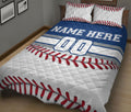 Baseball quilt blanket on a bed featuring bold blue, white, and red baseball-inspired artwork