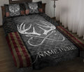 Hunting quilt blanket displayed on a bed with large antlers, patriotic stripes, stars, and rustic dark tones