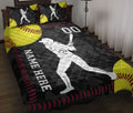 Softball quilt blanket on a bed with female batter artwork, yellow softballs, black background, and red stitching