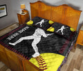 Softball quilt blanket styled on a bedroom bed with female batter artwork, yellow softballs, and red stitching