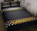 Black racing quilt blanket on a bed with checkered flag bands and yellow accent stripes