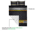 Close view of racing quilt design showing checkered flag print, diamond quilting, and white backing
