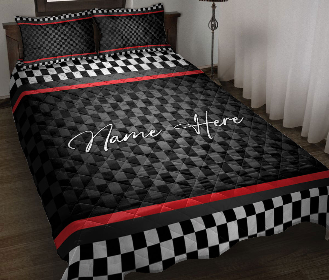 Racing quilt blanket on a bed with black and white checkered accents and red racing stripes