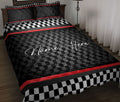 Racing quilt blanket on a bed with black and white checkered accents and red racing stripes