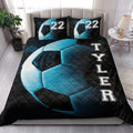 Black and blue soccer quilt blanket arranged in a bright bedroom with matching design accents