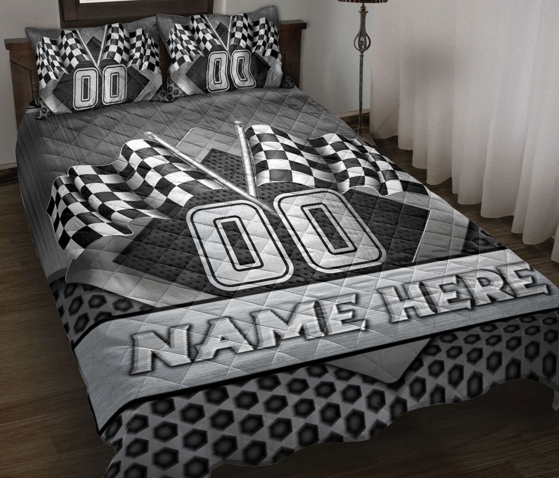 Custom racing quilt blanket displayed on a bed with checkered flags and bold black and gray motorsport artwork